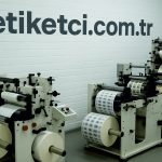 etiket üretim firması ve etiket makinelerinin yer aldığı duvarda etiketci.com.tr yazan bir görsel